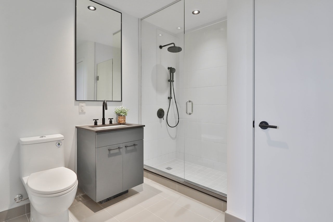 Aseo compacto reformado con ducha, lavabo y grifería moderna